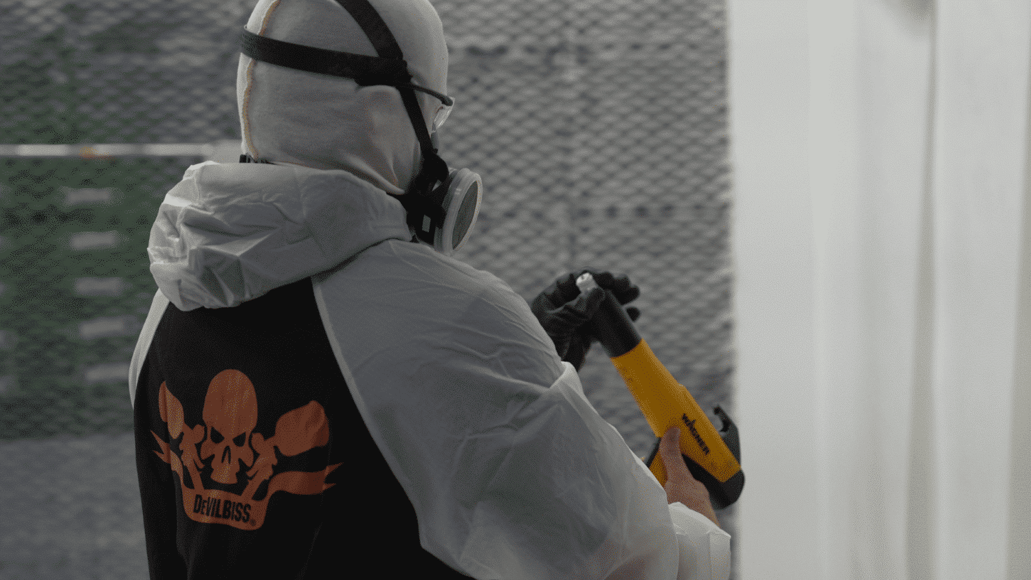 A worker in devilbiss ppe looking at a wagner paint gun